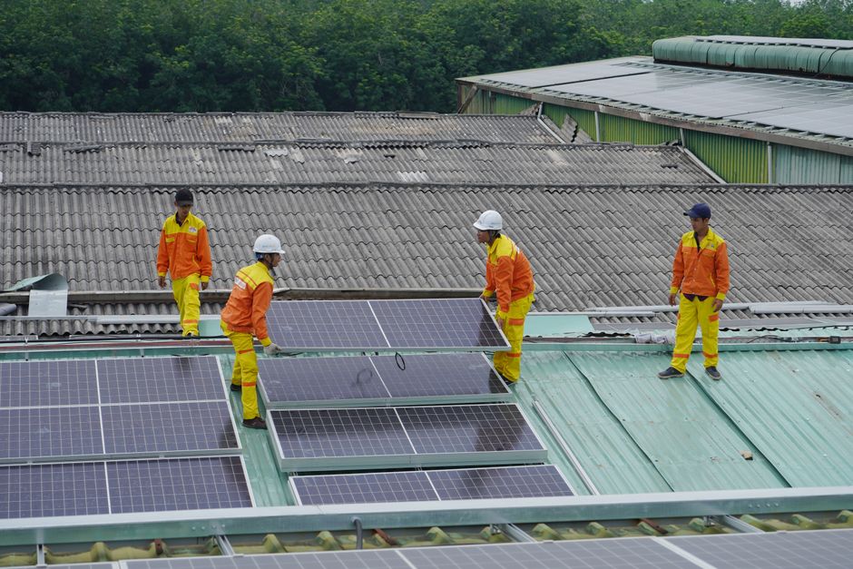 Professionals installing solar roof panels on a home